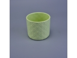 Green ceramic candle vessel with embossed surface